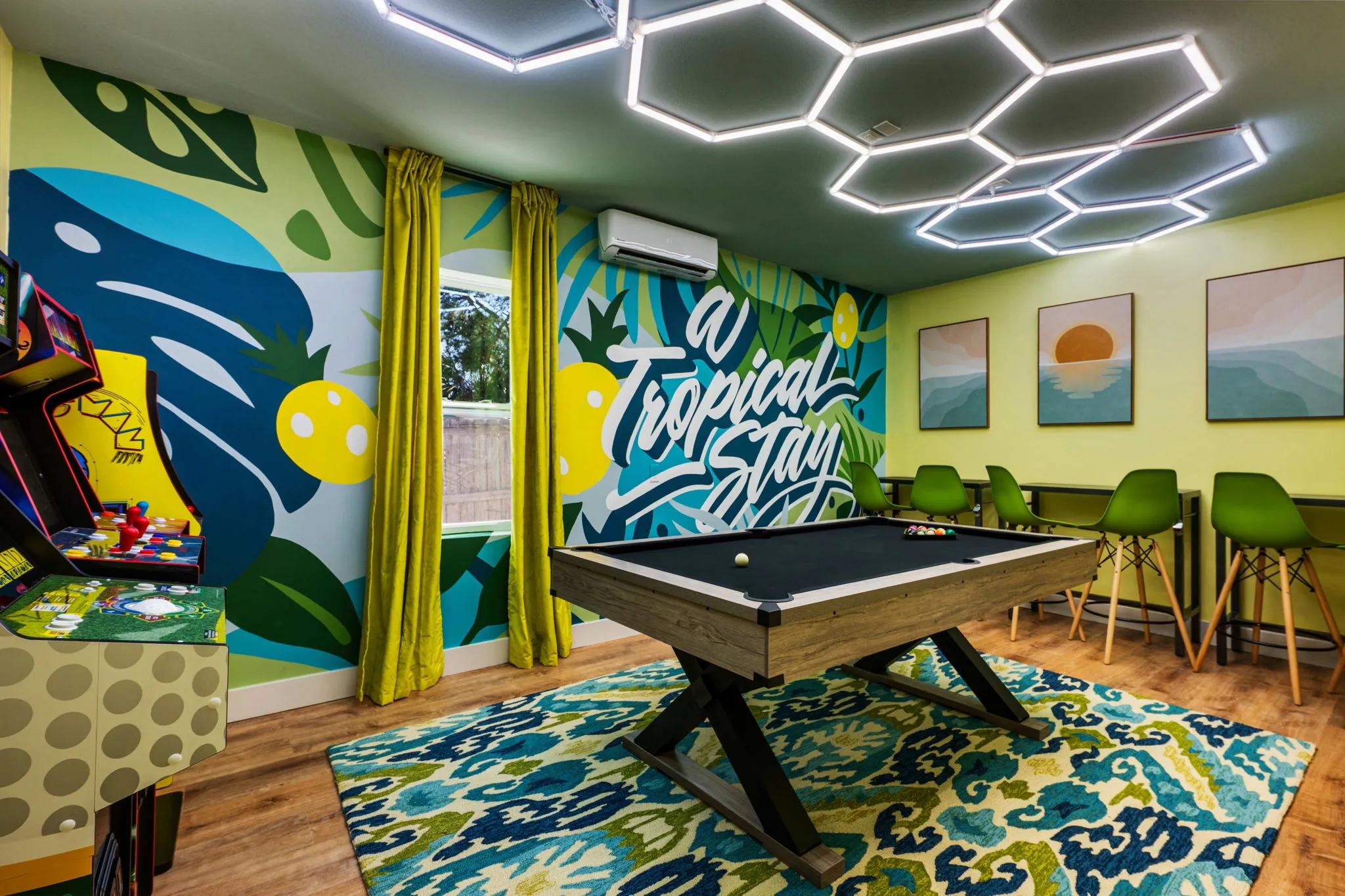 Modern game room with a black felt pool table, arcade machines