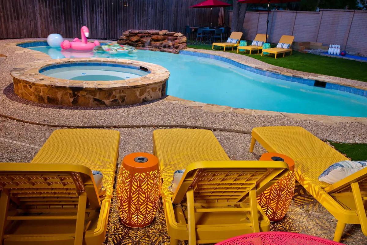 Family Oasis circular hot tub beside the swimming pool at night