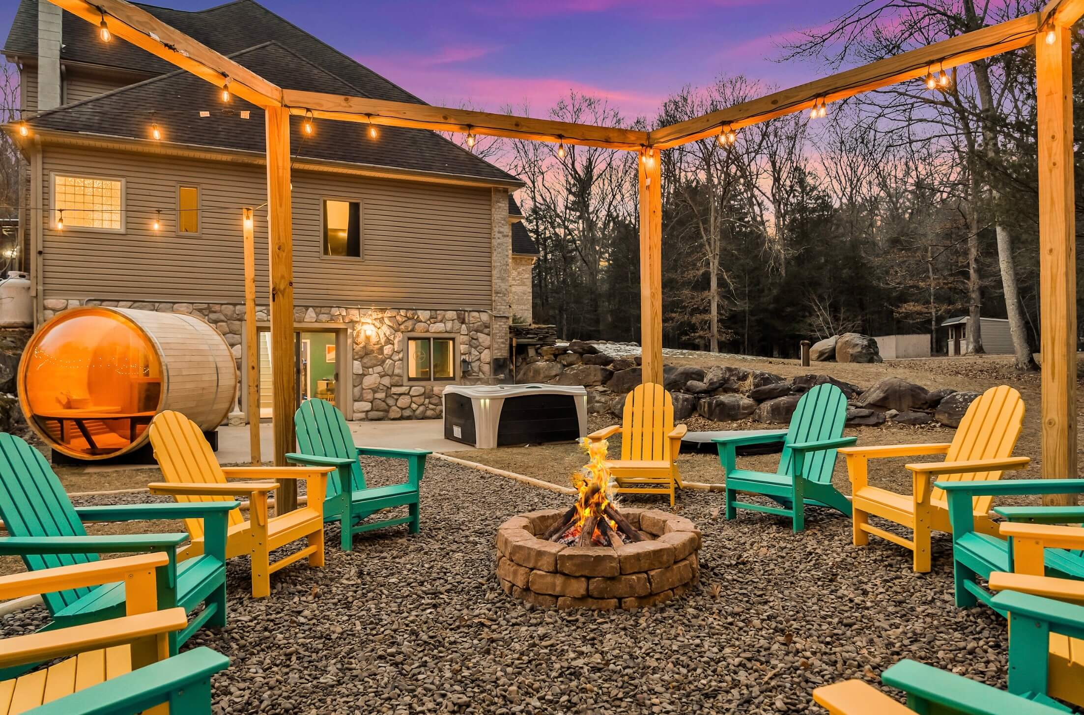 Outdoor fire pit surrounded by alternating yellow and teal chairs.