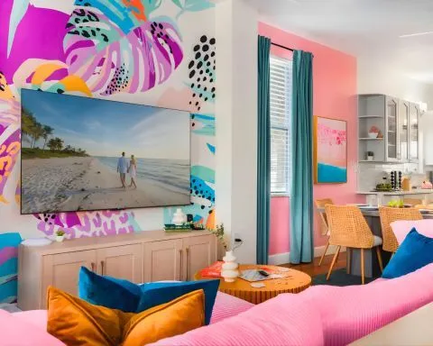 Bright living room with a pink sofa and colorful cushions.